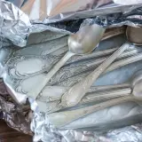Stare, ozdobne łyżki i widelce w folii aluminiowej. Czas na ich czyszczenie, by znów lśniły jak nowe.
