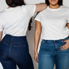 Dwie kobiety w białych T-shirtach i jeansach. Stylizacje z wysokim stanem podkreślają sylwetkę, pokazując jak ukryć brzuch.