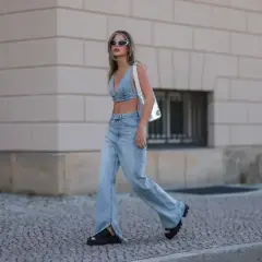 Modna kobieta w jeansach flare i denimowym topie, prezentująca letnie stylizacje.