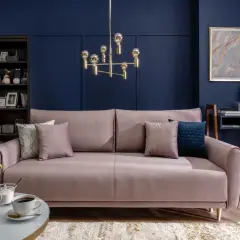 Elegancki salon w stylu art deco z różową sofą, złotym żyrandolem i granatową ścianą.