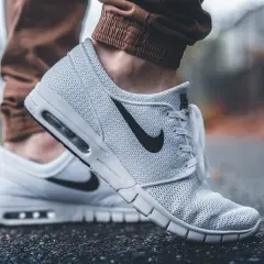 Białe buty Nike na siateczkowanej cholewce, z czarnym logo. Dowiedz się, jak wyczyścić białe buty, by wyglądały jak nowe.
