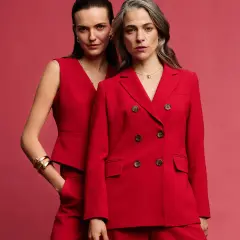 Dwie kobiety w czerwonych stylizacjach. Złota biżuteria podkreśla elegancję. Jaki kolor pasuje do czerwonego? Złoto!