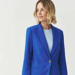 Kobieta w eleganckim, niebieskim żakiecie. Kolor kobaltowy a chabrowy idealnie podkreśla jej styl.