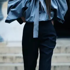 Eleganckie stylizacje z czarnymi spodniami. Szara, bufiała bluzka z kokardą i dopasowane czarne spodnie tworzą szykowny zestaw.