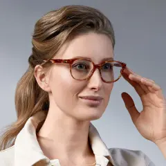 Elegancka kobieta z upiętymi włosami, prezentująca stylowe fryzury do okularów damskie. Jej spojrzenie podkreślają modne oprawki.