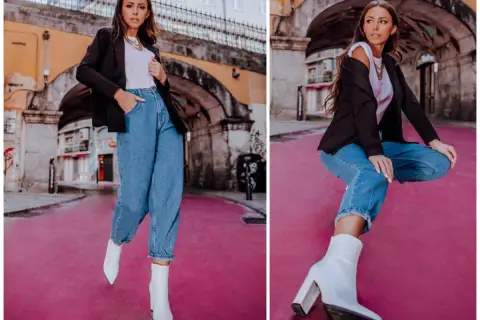 Kobieta w mom jeans i białych kozaczkach na słupku. Idealne buty do mom jeans, które podkreślą stylizację.