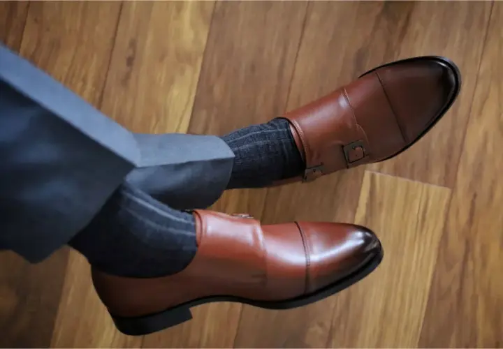 Eleganckie, brązowe buty monk strap i grafitowe skarpetki w prążki. Idealne połączenie, gdy zastanawiasz się, jakie skarpetki do brązowych butów pasują.