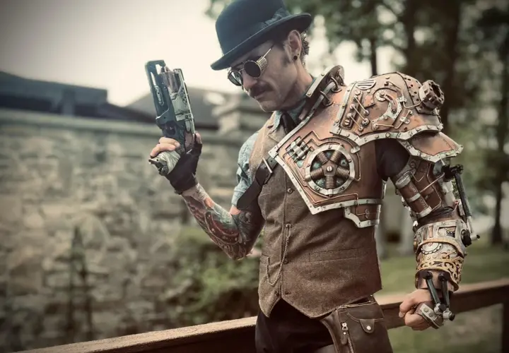 Mężczyzna w stylu steampunk, z cylindrem i goglami, trzyma futurystyczny pistolet. Jego zbroja na ramię i rękę jest pełna mechanicznych detali.
