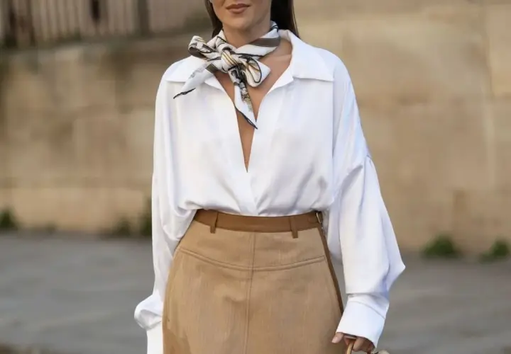 Elegancka biała koszula i brązowe spodnie to świetny sposób, jak ukryć duży brzuch, dodając stylowy szalik.