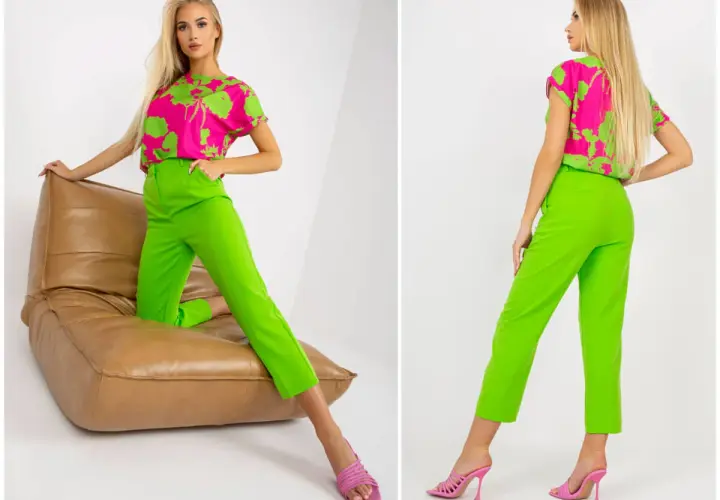 Modelka w stylizacji z bluzką w intensywny wzór i spodniami w kolorze limonkowym, siedząca na brązowej poduszce.
