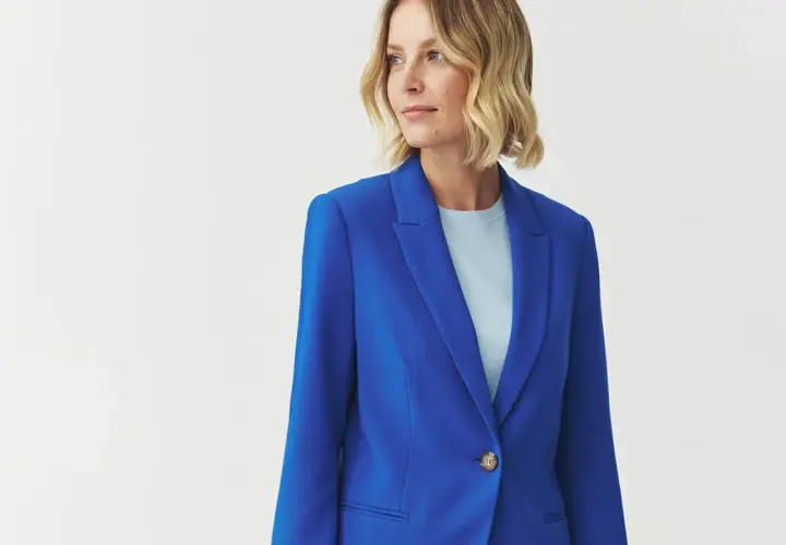 Kobieta w eleganckim, niebieskim żakiecie. Kolor kobaltowy a chabrowy idealnie podkreśla jej styl.