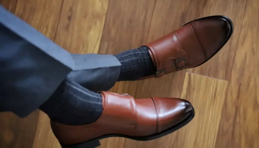 Eleganckie, brązowe buty monk strap i grafitowe skarpetki w prążki. Idealne połączenie, gdy zastanawiasz się, jakie skarpetki do brązowych butów pasują.