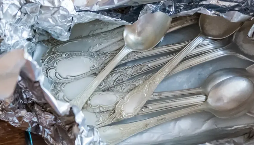 Stare, ozdobne łyżki i widelce w folii aluminiowej. Czas na ich czyszczenie, by znów lśniły jak nowe.