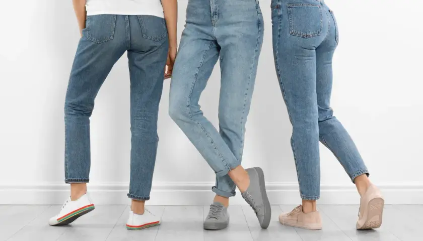 Trzy kobiety w jeansach. Dowiedz się, jak rozciągnąć jeansy w pasie, by były idealnie dopasowane.