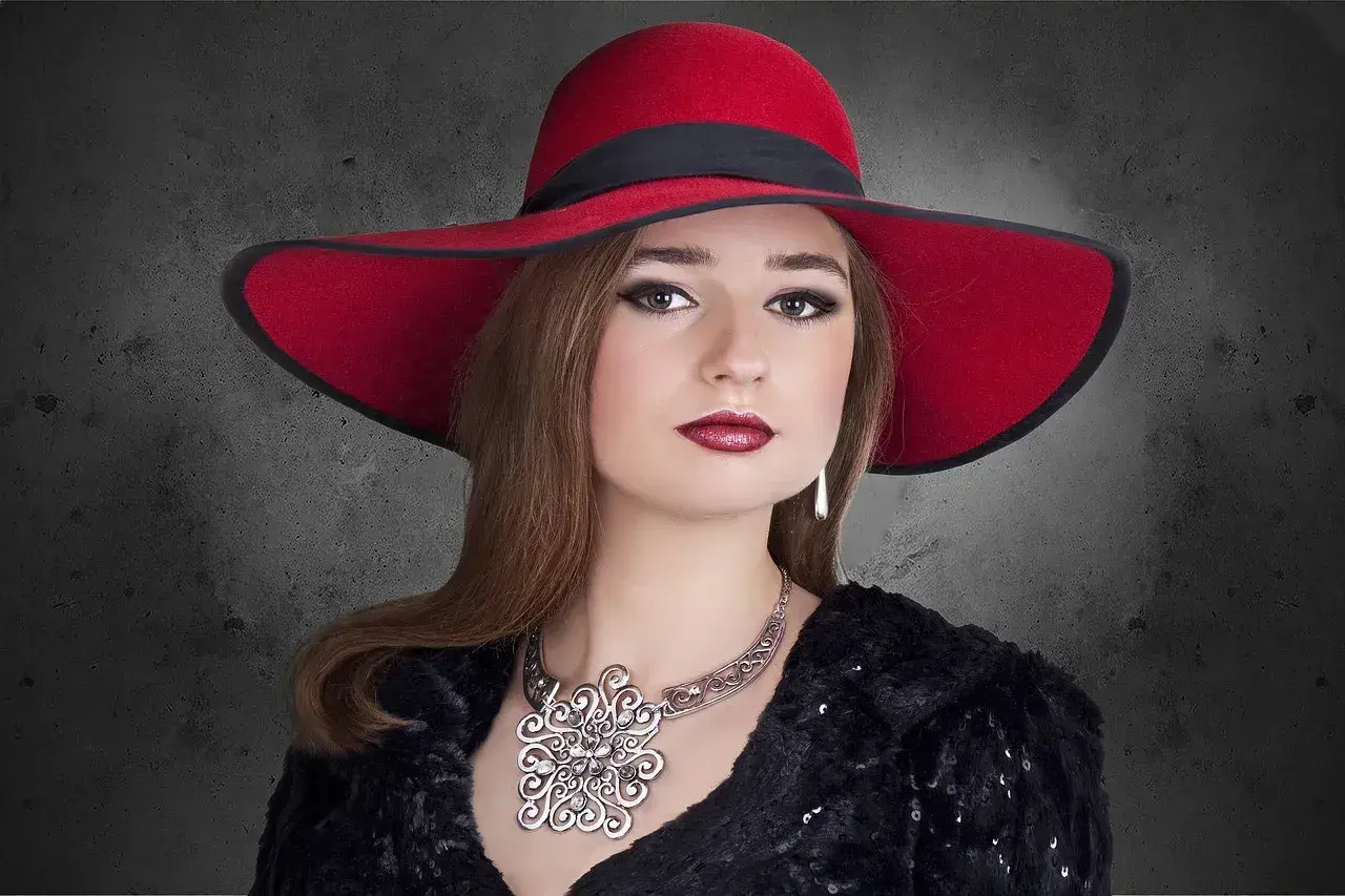 Elegancka kobieta w czerwonym kapeluszu i biżuterii, uosobienie stylu marki premium.