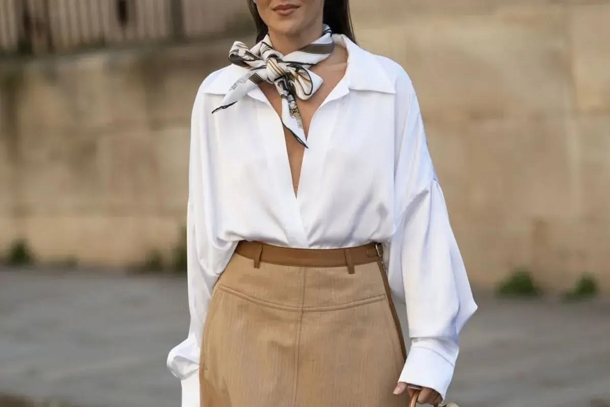 Elegancka biała koszula i brązowe spodnie to świetny sposób, jak ukryć duży brzuch, dodając stylowy szalik.