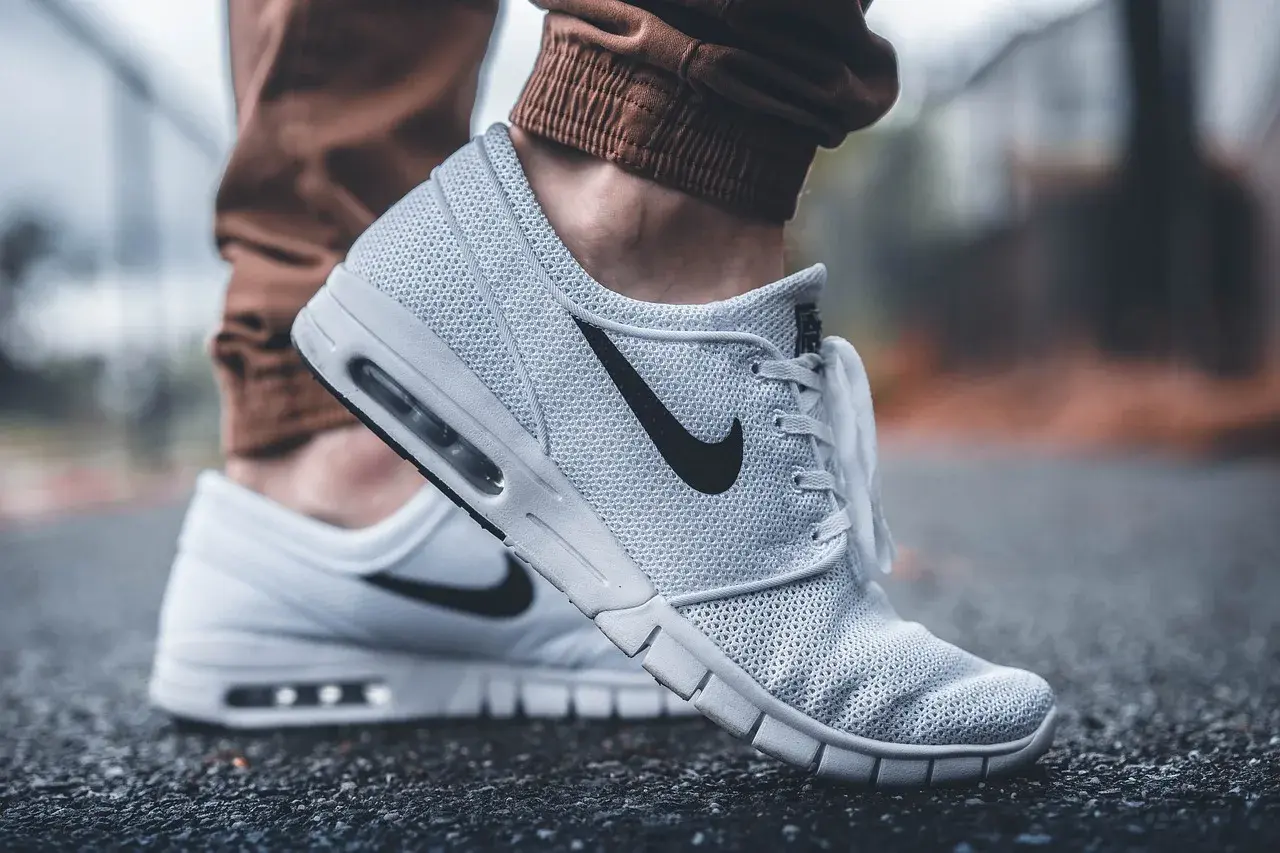 Białe buty Nike na siateczkowanej cholewce, z czarnym logo. Dowiedz się, jak wyczyścić białe buty, by wyglądały jak nowe.
