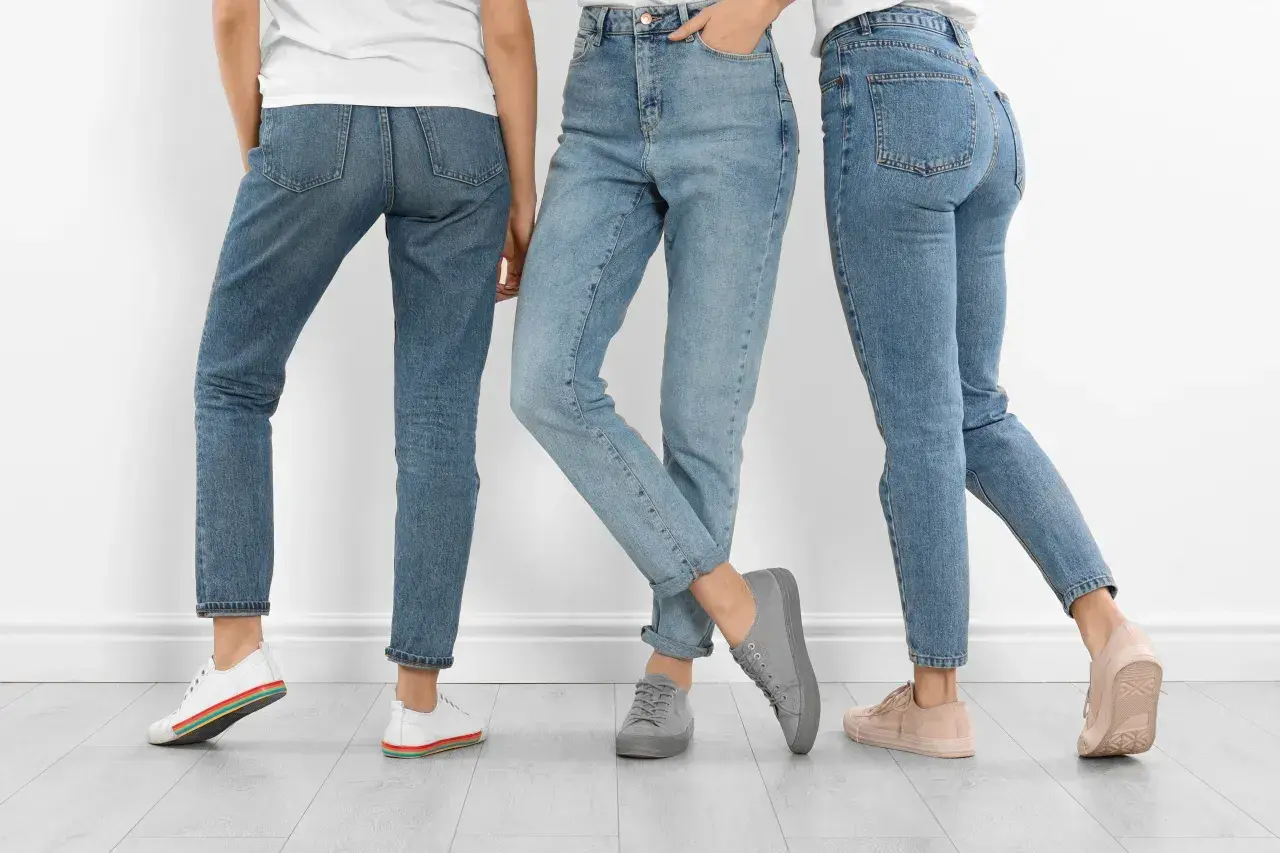 Trzy kobiety w jeansach. Dowiedz się, jak rozciągnąć jeansy w pasie, by były idealnie dopasowane.