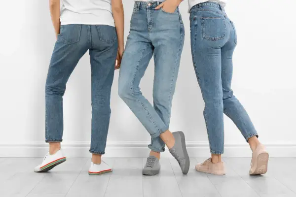 Trzy kobiety w jeansach. Dowiedz się, jak rozciągnąć jeansy w pasie, by były idealnie dopasowane.